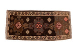 Vintage distressed Kars rug with three geometric medallions in dark brown, sand, and blush pink tones.
