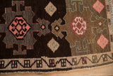 Detail of geometric blossoms in pink and blush on the low pile of a vintage Turkish Kars rug.