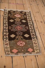 Angled view of a vintage Kars rug highlighting its triple geometric medallions and distressed character.