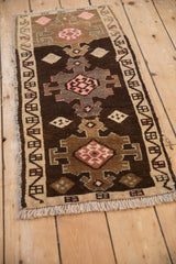 Distressed vintage Kars mat viewed from an angle, showing geometric medallions and abrashes.