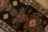Textured pile of a distressed vintage Kars rug with geometric motifs in bronze, blush pink, and sand.