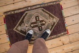Perspective view showing the scale of a distressed Kars rug with a central medallion and colorful fringe.