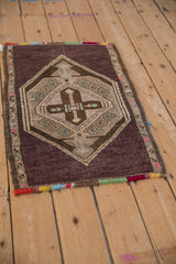 High-angle view of a vintage distressed Kars rug, highlighting its colorful fringe and geometric medallion.