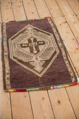 Angled view of a distressed Kars rug mat highlighting its geometric medallion and colorful fringe.