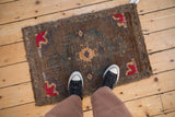 Distressed Kars rug's wool pile showing geometric patterns in red, bronze, and aubergine abrashes.