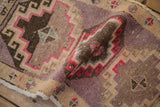 The flexible weave and low, distressed pile of a hand-knotted Kars rug with geometric motifs.