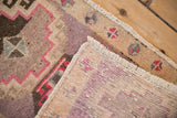 A folded corner reveals the hand-knotted foundation and low pile of a vintage Turkish Kars rug.