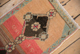 Distressed Kars rug detail: abrashed beige field, dark chocolate floral medallion, seafoam green vine border.