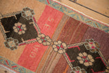 Kars rug detail: ruby red floral blossoms, dark diamond, dynamic abrash, and seafoam border.