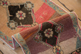 Distressed Kars rug's rolled pile, revealing abrashed copper and mauve tones, with seafoam green border.