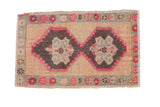 Vintage Kars rug with two interconnected charcoal medallions, fuchsia pink outlines, and a seafoam floral border.