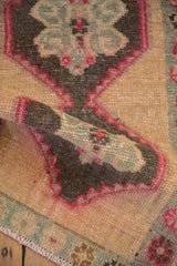 A vintage Kars rug is folded, showing the low pile texture and fuchsia-outlined medallion.