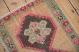 Detail of a vintage Kars rug showing stabilized fuchsia color run and worn, hand-knotted texture.