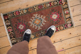 Distressed vintage Kars mat, geometric medallions in copper, magenta, and silver hues.