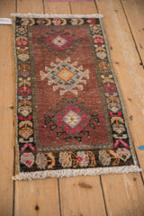 Distressed Kars rug mat upper corner: white fringe and dark geometric border with tendrils.