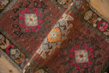Distressed Kars rug's textured pile, showing geometric tendrils and abrashed copper hues.