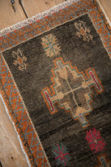 Distressed vintage Kars rug detail, charcoal field with serrated tangerine and gray border.