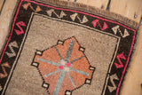 Distressed vintage Kars rug corner with beige field, magenta border, and worn fringe.
