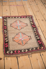 Distressed Kars rug with charcoal serpent border, magenta motifs, and time-softened beige pile.