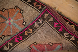 Distressed Kars rug's fringed edge with vivid magenta border accents and geometric motifs.