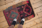 Distressed Kars mat, heavily abrashed ground with fuchsia geometric patterns and teal tones.