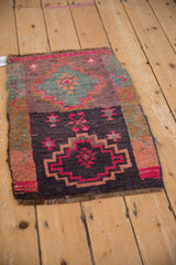 Distressed Kars rug detail with fuchsia stepped geometric medallion and blush germinating buds.