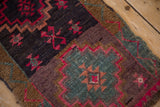 Kars rug close-up: distressed texture, fuchsia geometric patterns, deep plum and slate blue.