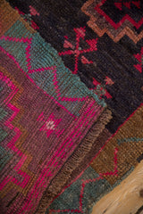 Textured Kars rug close-up, vivid fuchsia geometric patterns on charcoal, plum, and teal.