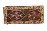 Distressed vintage Kars rug: chocolate double medallions with primitive mauve, blue motifs, abrashed ivory border.