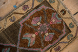 Close-up of primitive quatrefoil floral bouquet and meandering vine border on Kars rug.