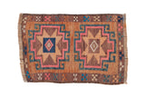 Distressed vintage Kars rug with double starburst medallions in warm copper, pink, and blue.
