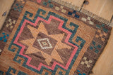 Vintage Kars rug detail: hook-and-latch geometry, even wear to knot heads, dusty colors, fringed end.