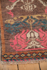 Narrow banded border with diamond motifs on a distressed Kars rug with a low, textured pile.