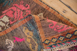 Folded corner of a vintage Kars rug showing its hand-knotted texture, even wear, and colorful border.