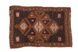 Distressed vintage Kars rug with a stepped geometric medallion in coffee brown, charcoal, and pink.