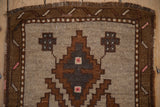 Detail of the worn, hand-knotted pile on a Kars rug's stepped geometric medallion and brown border.