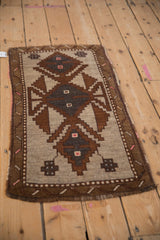 Angled view of a distressed Kars rug with a brown and silver geometric medallion.