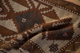 Textured, low pile of a hand-knotted Kars rug with stepped geometric designs in earthy bronze and silver.