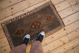 Distressed vintage Kars rug mat with faded pink, worn texture, and stepped geometric pattern.