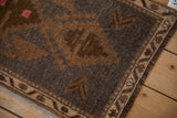 Vintage distressed Kars rug's geometric border and worn pile texture in charcoal and sand.