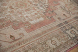 Distressed texture with faded dusty rose and beige floral Oushak rug pattern.
