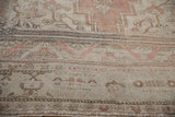 Distressed Oushak rug border showing even wear, faded dusty rose and cream motifs.
