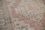 Distressed vintage Oushak rug detail: dusty rose field, faded floral motifs, and even wear.