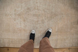 Evenly worn low pile of a distressed Oushak rug in soft beige and antique ivory tones.