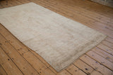 Evenly worn pile and machine-bound end on a vintage distressed Oushak rug runner.