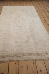 Low-angle view of a distressed Oushak runner highlighting its soft sheen and low pile texture.