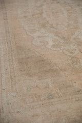 Close detail of even wear and dark wefting surfacing on a distressed Oushak rug pile.