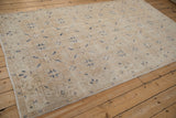 Distressed vintage Sparta carpet, light beige pile, faint foundation, navy floral motifs.