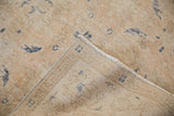 Distressed Sparta carpet's worn beige pile, faint foundation, and machine-bound reverse.