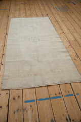 The reverse of a vintage Oushak runner showing the hand-knotted foundation and secured machine-bound edges.